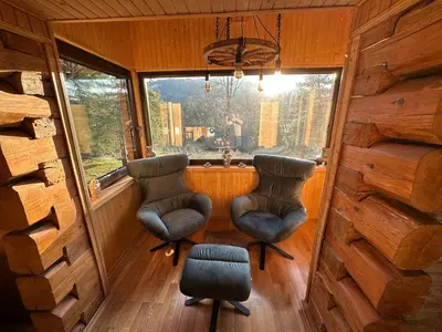 two chairs and a window in a tiny house at Gorczańska Chata Lubomierz in Lubomierz