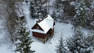 a small house covered in snow in a forest at Gorczańska Chata Lubomierz in Lubomierz