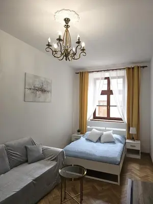 a living room with a bed and a couch at Pawia Apartments Old Town in Kraków