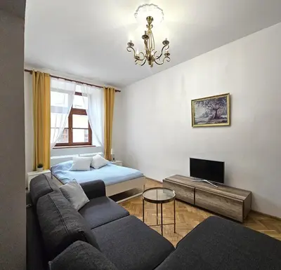a living room with a couch and a bed at Pawia Apartments Old Town in Kraków