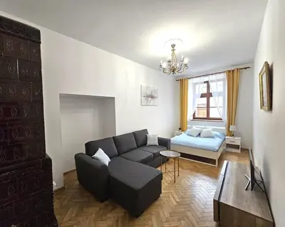 a living room with a couch and a bed at Pawia Apartments Old Town in Kraków