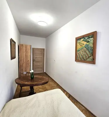 a room with a table and a bed and a painting at Pawia Apartments Old Town in Kraków