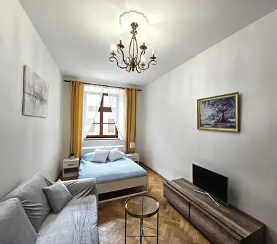 a living room with a bed and a couch at Pawia Apartments Old Town in Kraków