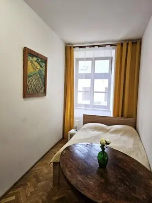 a bedroom with a table and a bed and a window at Pawia Apartments Old Town in Kraków