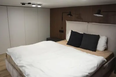 a bedroom with a large white bed with black pillows at Stradom Studio in Kraków