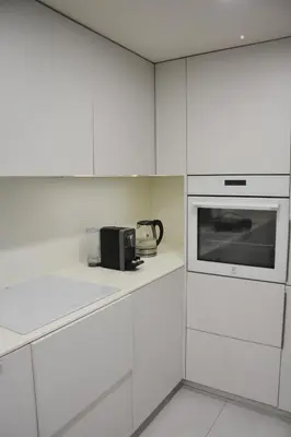 a kitchen with white cabinets and a microwave at Stradom Studio in Kraków