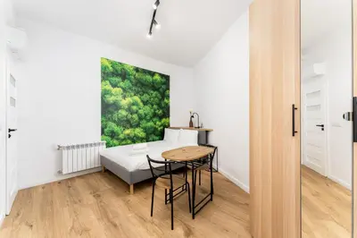 a dining room with a table and a painting on the wall at Cozy studio - Starowislna 54 Street in Kraków