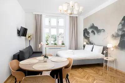 a room with a bed and a table and a couch at Cozy Studio - Starowislna 54 in Kraków