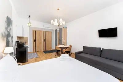 a living room with a bed and a couch at Cozy Studio - Starowislna 54 in Kraków