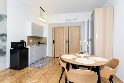 a kitchen and dining room with a table and chairs at Cozy Studio - Starowislna 54 in Kraków