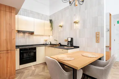 a kitchen with a wooden table and chairs at Urban Light Apartment - 3' Main Square - by Upstairs in Kraków
