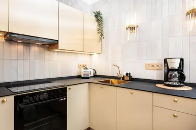 a kitchen with white cabinets and a sink at Urban Light Apartment - 3' Main Square - by Upstairs in Kraków