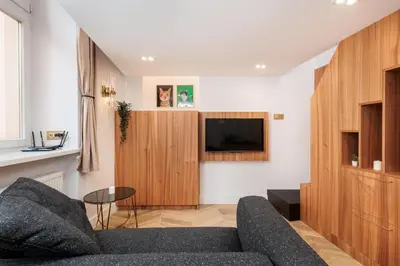 a living room with a couch and a tv at Urban Light Apartment - 3' Main Square - by Upstairs in Kraków