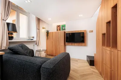 a living room with a couch and a flat screen tv at Urban Light Apartment - 3' Main Square - by Upstairs in Kraków