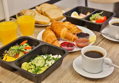 a table topped with trays of food and a cup of coffee at Urban Light Apartment - 3' Main Square - by Upstairs in Kraków