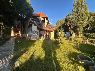 a house in the grass next to a building at Villatopol in Rząska