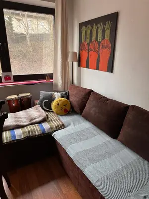 a living room with a brown couch and a window at Villatopol in Rząska
