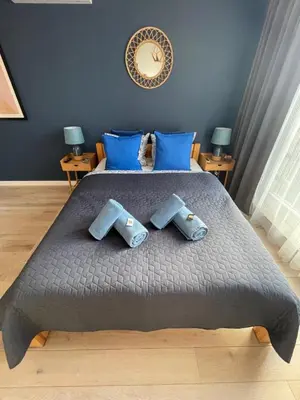 a bedroom with a large bed with blue pillows at Sunflower Apartment Bałuckiego Street in Kraków