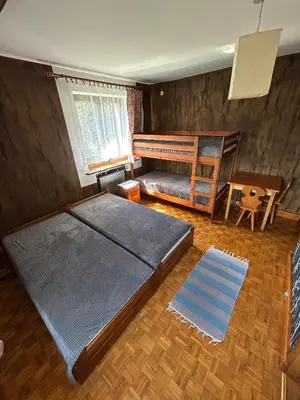 a bedroom with a bed and a crib and a table at Dom pod Cuplikiem in Zawoja