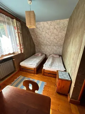 a small room with two beds and a window at Dom pod Cuplikiem in Zawoja