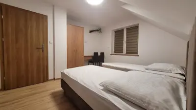 a bedroom with two beds and a wooden door at Wiślana 4 in Spytkowice