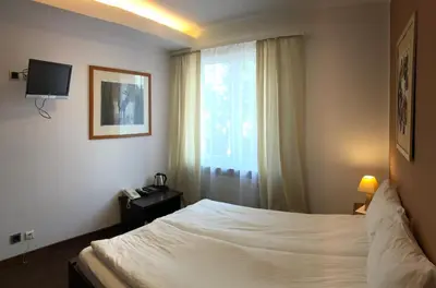a hotel room with a bed and a window at Hotel Olecki in Oświęcim
