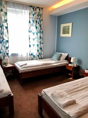 a bedroom with two beds and a window at Hotel Olecki in Oświęcim