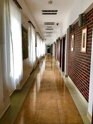 an empty hallway of a building with windows and a brick wall at Hotel Olecki in Oświęcim