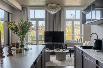 a kitchen with a living room with windows at So Soho Spa Collection in Kraków