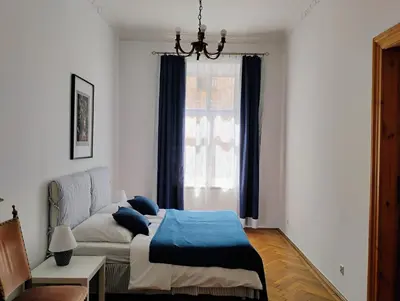 a bedroom with a bed and a window at Apartament Niebieski in Kraków