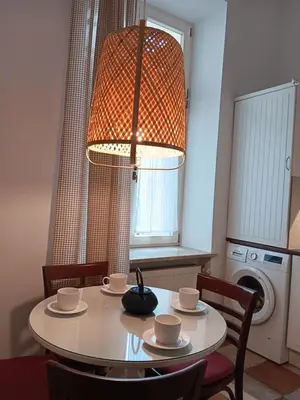 a dining room table with cups and saucers and a lamp at Apartament Niebieski in Kraków
