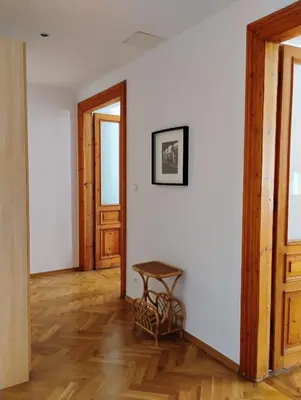 a room with a table on a white wall at Apartament Niebieski in Kraków