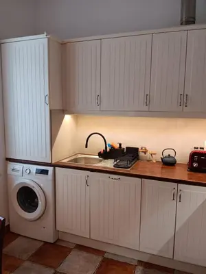 a kitchen with a sink and a washing machine at Apartament Niebieski in Kraków