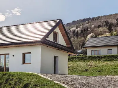 a white house with a brown roof on a hill at Beskidzka Kraina in Porąbka