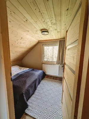 a small bedroom with a bed and a window at Beskidzka Kraina in Porąbka