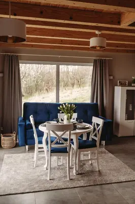 a dining room with a table and a blue couch at Beskidzka Kraina in Porąbka