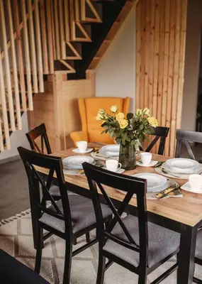 a wooden table with chairs and a vase of flowers at Beskidzka Kraina in Porąbka