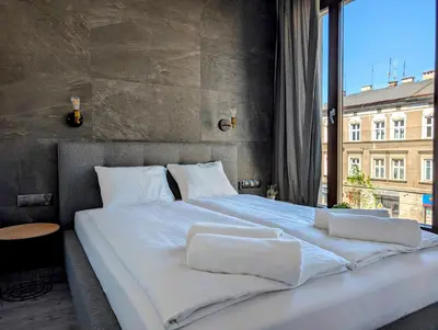 a large bed with white sheets and pillows on it at Kościuszki 28 B by Homeprime in Kraków