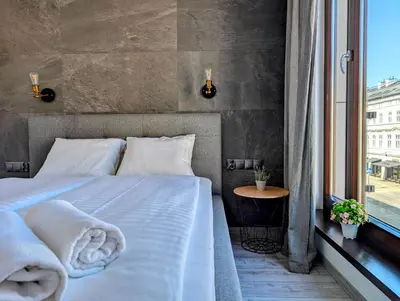 a bedroom with a bed with white sheets and a window at Kościuszki 28 B by Homeprime in Kraków