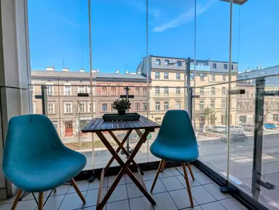 two blue chairs and a table in front of a window at Kościuszki 28 B by Homeprime in Kraków