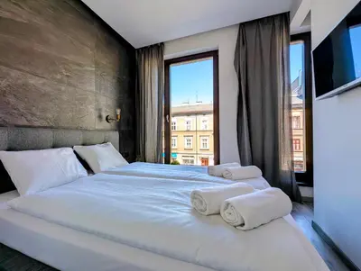a bedroom with a large bed with towels on it at Kościuszki 28 B by Homeprime in Kraków