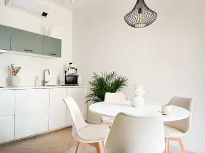 a white kitchen with a white table and chairs at Studio Premium with Air Conditioning for couples in the heart of Krakow, Main Square in Kraków