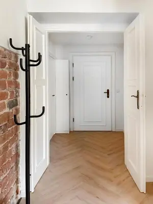 an empty room with a brick wall and a white door at Studio Premium with Air Conditioning for couples in the heart of Krakow, Main Square in Kraków