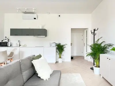 a white living room with a couch and a kitchen at Studio Premium with Air Conditioning for couples in the heart of Krakow, Main Square in Kraków