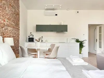 a kitchen and dining room with a white bed and chairs at Studio Premium with Air Conditioning for couples in the heart of Krakow, Main Square in Kraków