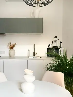 a kitchen with white cabinets and a white table at Studio Premium with Air Conditioning for couples in the heart of Krakow, Main Square in Kraków