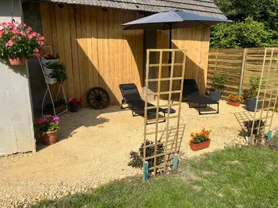 a garden with chairs and an umbrella and a ladder at Wiejska Przystań blisko Energylandii in Po”łwieś