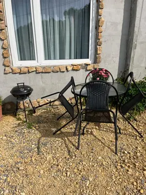 a patio with two chairs and a table and a window at Wiejska Przystań blisko Energylandii in Po”łwieś
