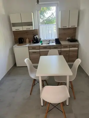 a white kitchen with a white table and chairs at Wiejska Przystań blisko Energylandii in Po”łwieś