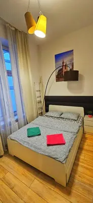 a bedroom with a bed with two colored sheets at M Apartment Bosacka 7 in Kraków
